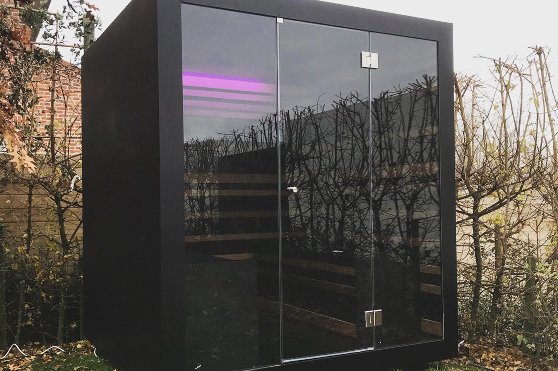 Black Aluminium Sauna With LED Lights. Image shows one of Thermalux's premium outdoor saunas in a garden setting. Thermalux UK are suppliers of Premium Outdoor Saunas, Luxury Outdoor Saunas, and Aluminium Finish Saunas.