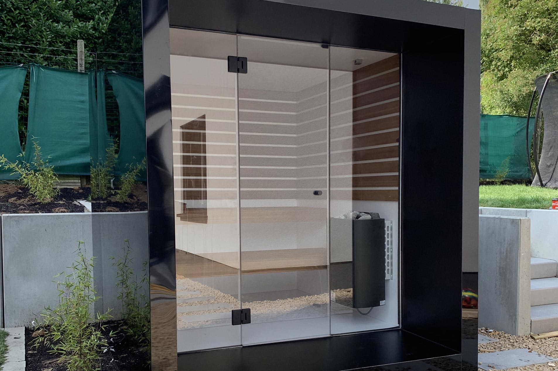 Image shows one of Thermalux's premium outdoor saunas in a garden setting. Thermalux UK are suppliers of Premium Outdoor Saunas, Luxury Outdoor Saunas, and Aluminium Finish Saunas like this one.